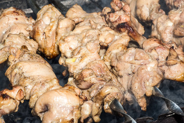 Grilled kebab cooking on metal skewer closeup. Roasted meat cooked at barbecue. BBQ fresh beef meat chop slices. Traditional eastern dish, shish kebab. Grill on charcoal and flame, picnic, street food