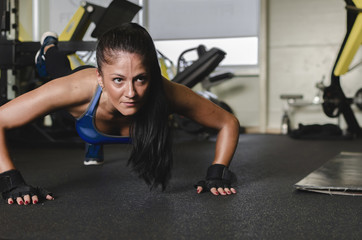 Fototapeta na wymiar Woman at gym doing push-ups