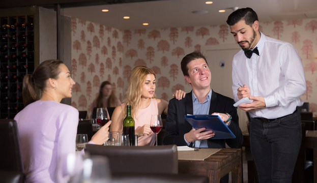 Adult waiter taking order in restaurant