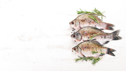 Raw Fish with Spices and Vegetables. Carp On a wooden background. Top view. Copy space.