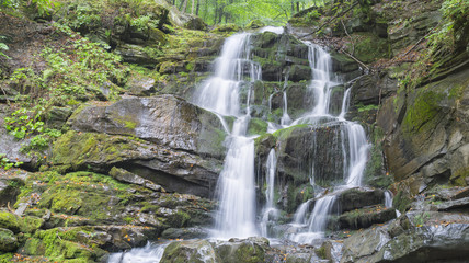 cascades of big waterfall on the rocks wall
