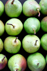 Flat lay of fresh pears on black background. From above, overhead, flat lay. Closeup.