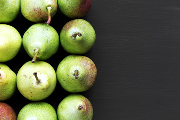 Fresh pears on dark background, from above. Top view, overhead, flat lay. Copy space.