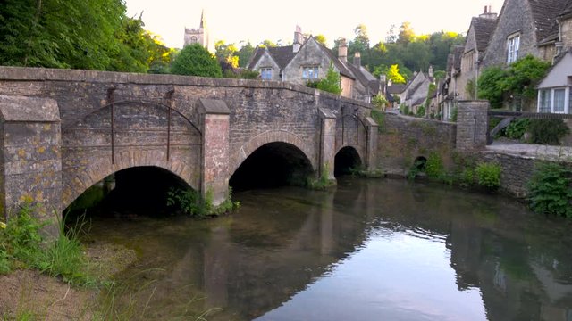 Beautiful bridge over peaceful river in idyllic village