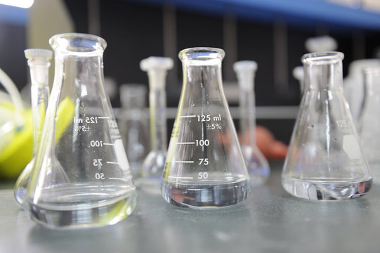 Laboratory glassware containing colorful chemical liquid, lab research and development concept