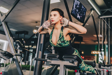 Fototapeta na wymiar sport, fitness, bodybuilding, lifestyle and people concept - young girl doing sit-up abdominal exercises Sports young woman doing exercises on trainer back machine in the gym
