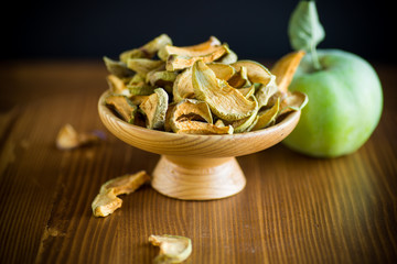 Dried apples in a bowl with a fresh apple