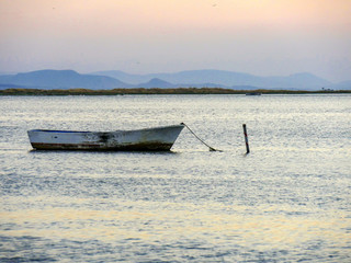 Fishing boat anchored in Aegean sea with sunset view at izmir, Turkey.