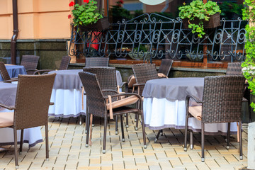Fototapeta na wymiar Chairs and tables in cozy outdoor cafe at summer
