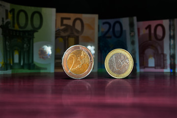 Close Up Euro Money Banknotes And Highlighted Coins With Reflection On The Table In Vertical Position. cash Background. Money Bills. Finance And Economy Concept. Selective focus.