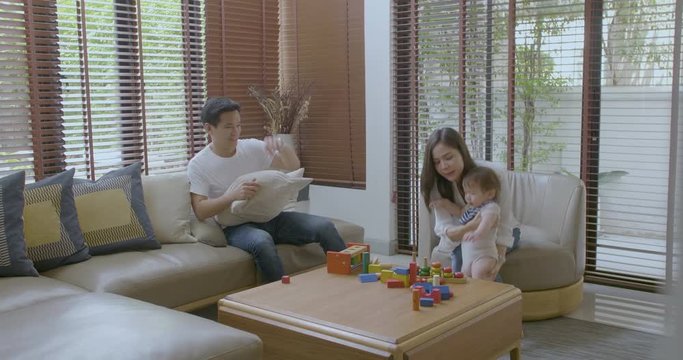 Happy mother, father and little asian boy playing with wooden toy blocks at home. Educational Toys for preschool and kindergarten child.