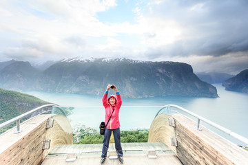 Tourist photographer with camera on Stegastein lookout, Norway