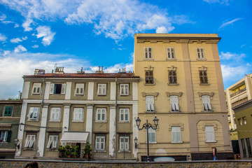 italian colorful buildings facade in empty small cozy yard in summer bright contrast day time