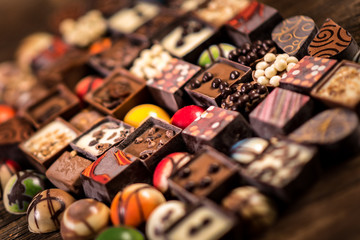 Assorted chocolate pralines on the wooden background