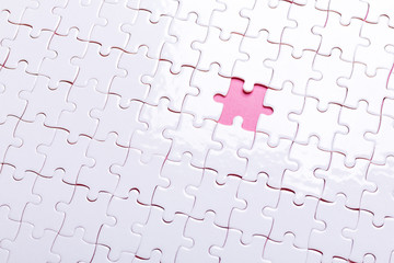 White puzzle on pink background. Missing piece. Top view