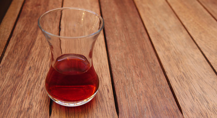 Traditional Turkish tea in the traditional glass on wooden table.