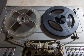 Old reel-to-reel recorder with magnetic tape on it