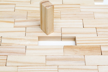 Hand adding final piece to block tower. Business solutions and problem solving concept