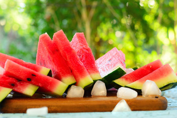 Watermelon slices with slices of ice on table
