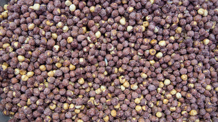 Pile of roasted and salted, not peeled hazelnuts top view background. Lots of brown nut seeds, healthy vegan and vegetarian food