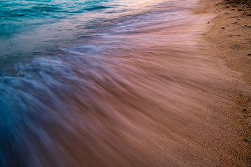 A blurry wave crashing on the shore