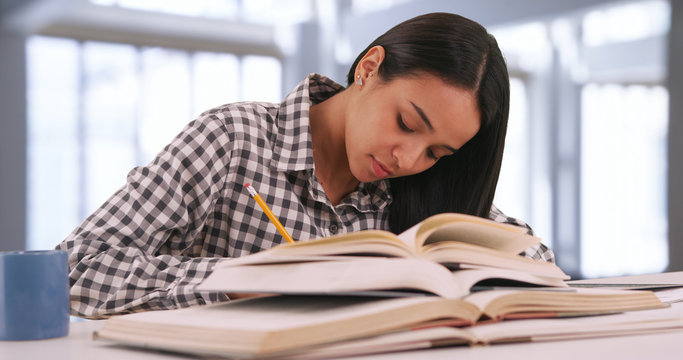 Hispanic female college student studies for an exam at her campus study hall 