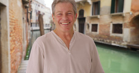 Happy older Caucasian man enjoys his vacation in Venice