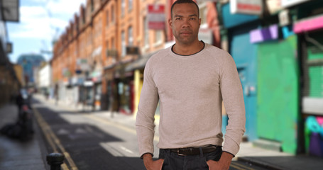 Fototapeta premium Bold young African-American man poses confidently in urban setting