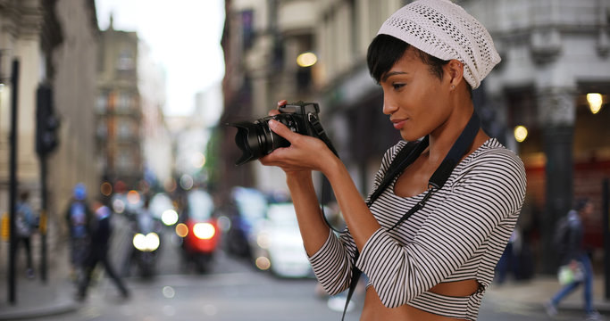 Modern black woman millennial taking shots of London city on camera 