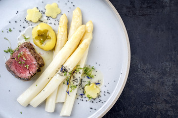 Modern style German barbecue dry aged sliced fillet steak with white asparagus and roast potatoes...