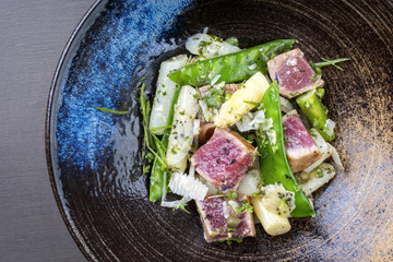 Modern style fried tuna fish tataki filet salad with white asparagus sugar snaps and parmesan...