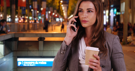 White female professional makes call on phone after arriving at Champ-Elysees