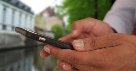 Close up of Latino businessman text messaging on smart phone