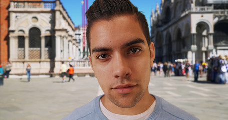 Wide angle of Latin male in St Marks square looking directly at camera