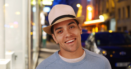 Attractive happy Latino male smiling on city street ready for the club 