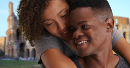 Portrait of happy black millennial couple talking and relaxing near Coliseum
