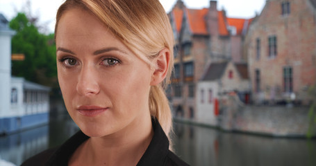 Fototapeta premium Close-up portrait of gorgeous white woman looking intently at camera in Bruges