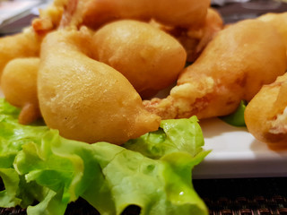 Portion of giant shrimps in deep-fried with green lettuce leaves
