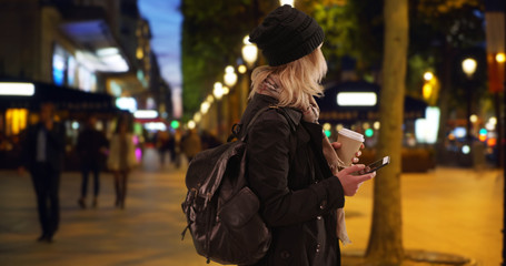 Confused blonde female tourist in Paris navigating location at Champs-Elysees