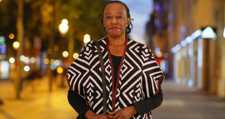 Portrait of happy senior black woman on Champs Elysees avenue at night