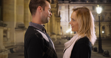 Loving young caucasian couple outdoors together at night