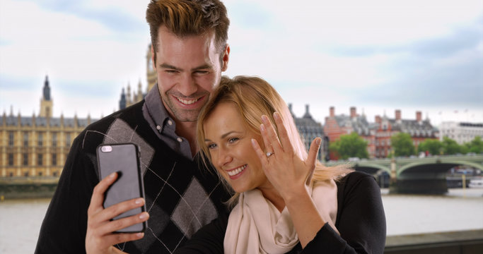 Newly engaged couple take a selfie in London to share the news with friends