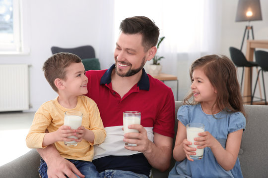 Happy family with glasses of milk in living room