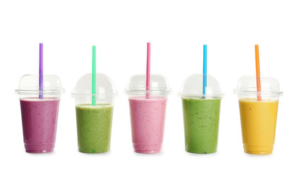 Plastic cups with fresh tasty smoothies on white background