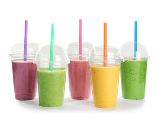 Plastic cups with fresh tasty smoothies on white background