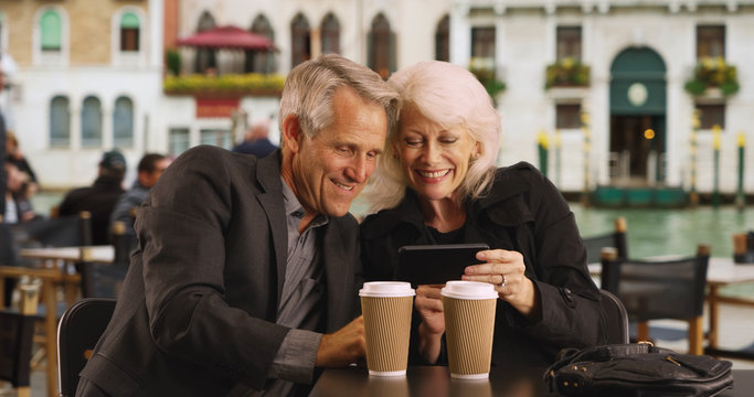 Portrait of Caucasian male and female using mobile device on their vacation