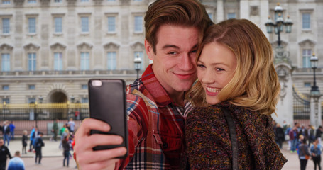 Cheerful young couple taking a selfie in London