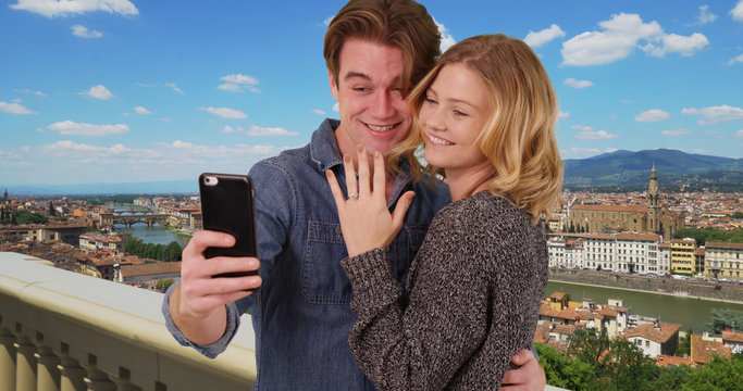 Newly engaged couple taking a selfie in Florence smiling and laughing