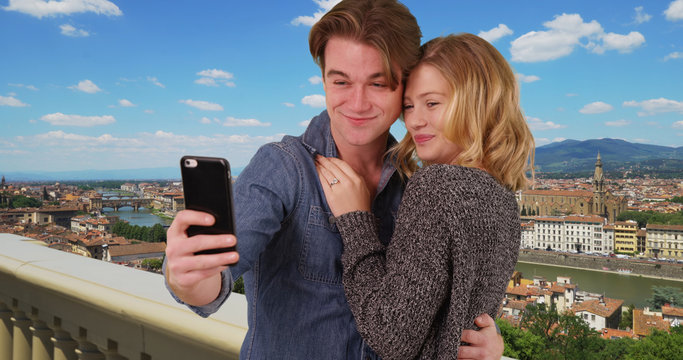 Newly engaged couple taking a selfie in Florence smiling and laughing