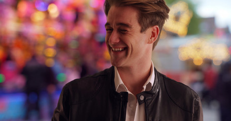 Cool and handsome young man at county fair smiling and laughing at camera